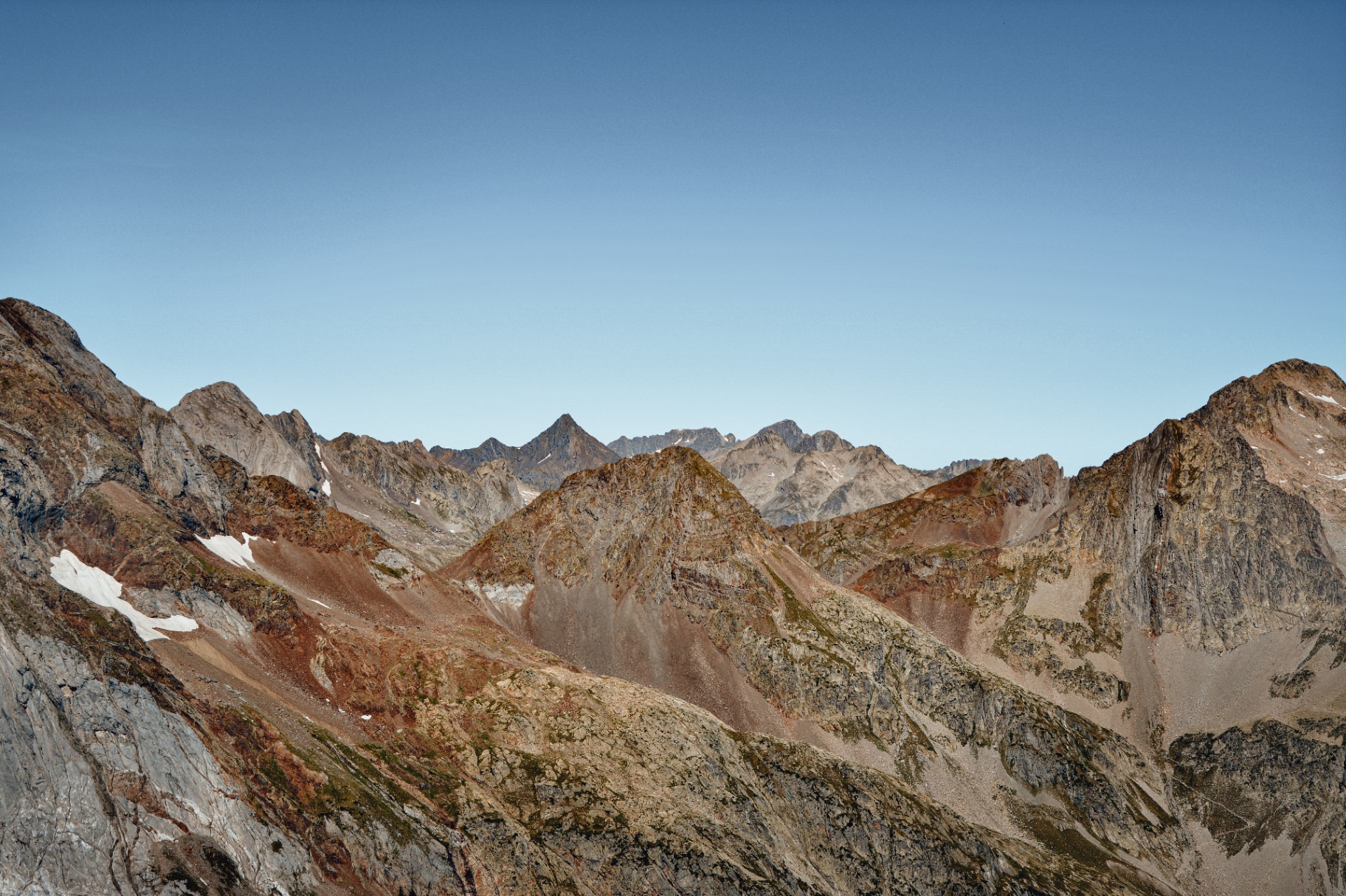 Crêtes pyrénéennes découpées dans la douce lumière de l'aube sous un ciel bleu pur